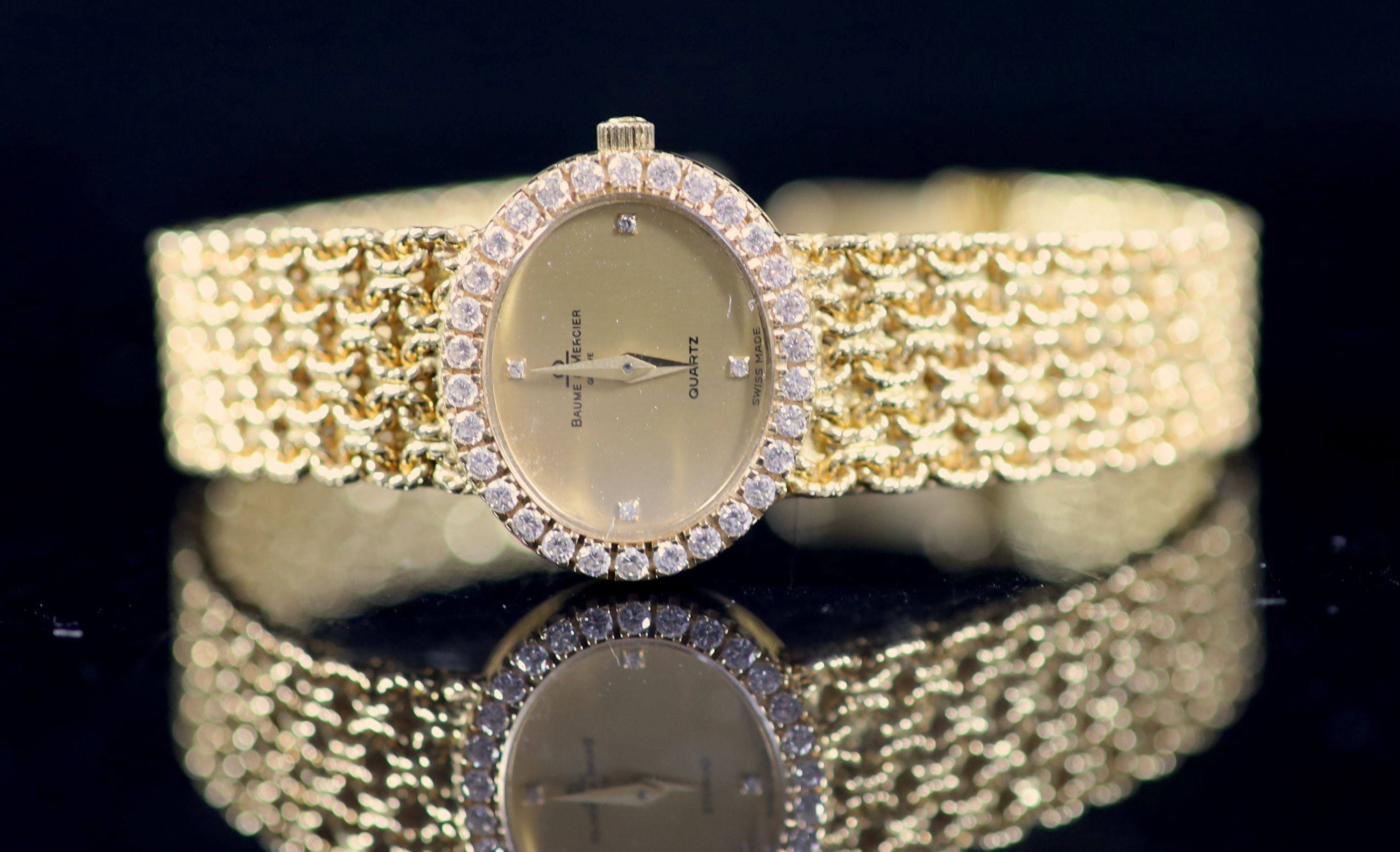 A lady's 18ct gold Baume & Mercier quartz oval dress bracelet wrist watch, with diamond set bezel
